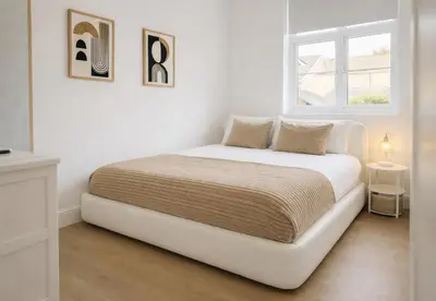 a white bed in a white room with a window at Louisville Flat 3 in Newmarket