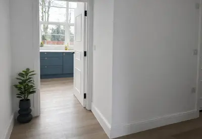 a kitchen with white walls and a potted plant at Louisville Flat 3 in Newmarket