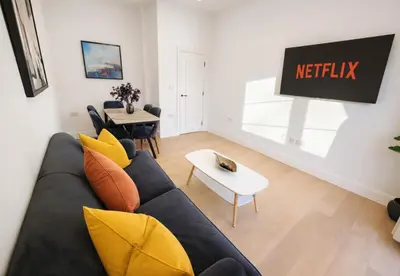 a living room with a couch and a table at Louisville Flat 3 in Newmarket