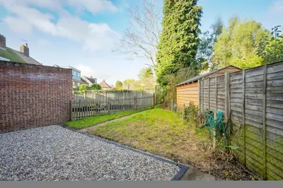 a backyard with a fence and a brick wall at Keralia in Wivenhoe