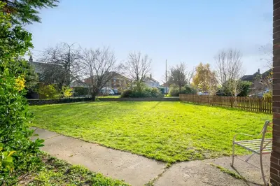 a park with a bench in the middle of a yard at Keralia in Wivenhoe