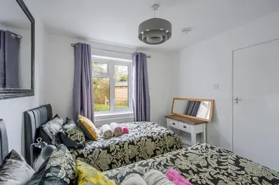 a hotel room with two beds and a window at Keralia in Wivenhoe