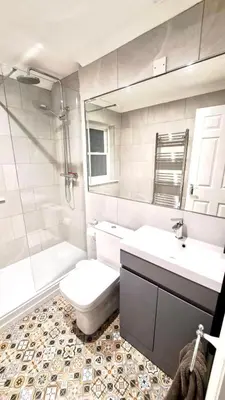 a bathroom with two sinks and a toilet and a shower at Charming 1-Bedroom Flat - Chelmsford City Centre in Chelmsford