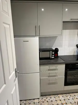 a kitchen with white cabinets and a white refrigerator at Charming 1-Bedroom Flat - Chelmsford City Centre in Chelmsford