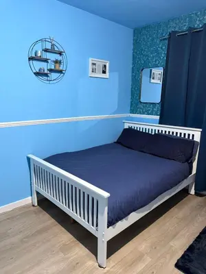 a blue bedroom with a bed with a blue wall at The Aqua Stay By Cambridge City Centre in Chesterton