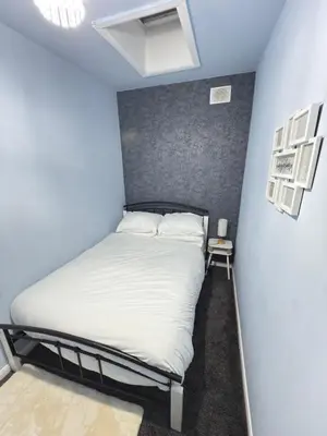 a bed in a room with a blue wall at Quiet Blue Rooms By Cambridge City Centre in Chesterton