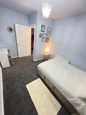 a bedroom with a bed and a blue wall at Quiet Blue Rooms By Cambridge City Centre in Chesterton