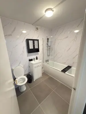 a bathroom with a toilet and a tub and a sink at Quiet Blue Rooms By Cambridge City Centre in Chesterton