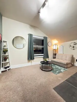 a living room with a couch and a window at The Modern Nest By Cambridge Central Station in Cambridge