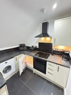 a kitchen with white appliances and a stove top oven at The Traveller's Nest by Cambridge Central Station in Cambridge
