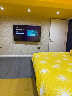 a bedroom with a bed with a television on the wall at The Squid Escape By Cambridge Central Station in Cambridge