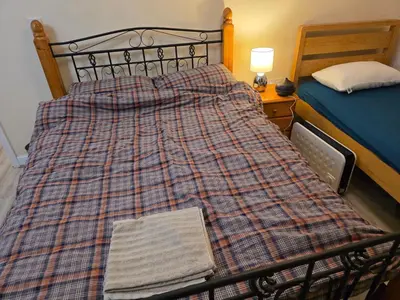 a bed with a plaid blanket on it in a bedroom at Colchester Hythe home in Hythe