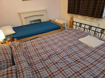 a bedroom with a bed with a plaid blanket at Colchester Hythe home in Hythe