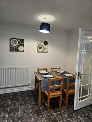 a dining room with a table and four chairs at Duxford Haven in Duxford
