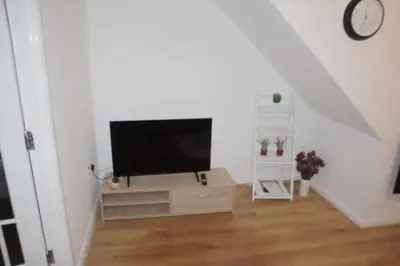 a living room with a flat screen tv on a stand at Duxford Haven in Duxford
