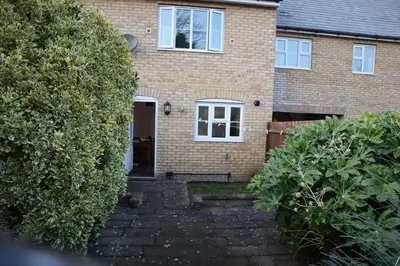 a brick house with a staircase leading to the front door at Duxford Haven in Duxford