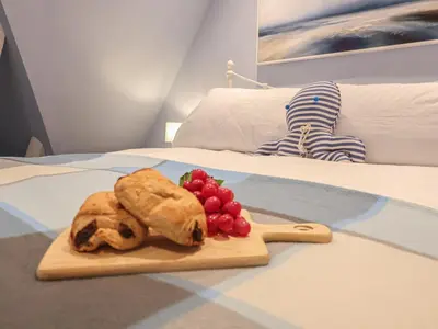 a cutting board with fruit on a bed at The Nutshell in Aldeburgh