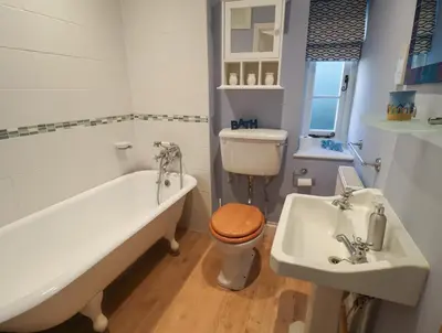 a bathroom with a tub and a toilet and a sink at The Nutshell in Aldeburgh