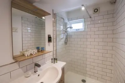 a white bathroom with a sink and a shower at The Nutshell in Aldeburgh