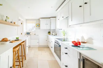 a white kitchen with white counters and white cabinets at 2 Truman Lodge in Thorpeness