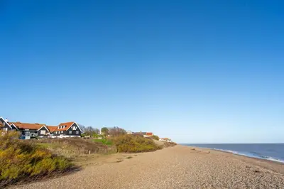 a beach with houses and the ocean at 2 Truman Lodge in Thorpeness