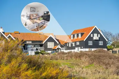 a large black house with an orange roof at 2 Truman Lodge in Thorpeness