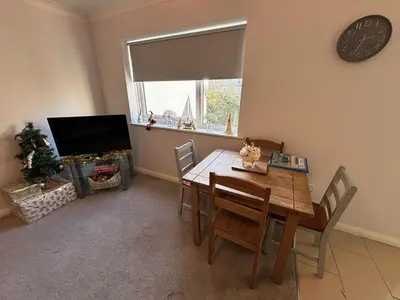a dining room with a table and chairs and a television at Canal Side Retreat in Maldon