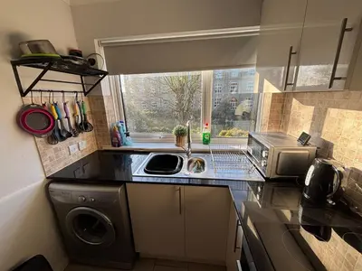 a kitchen with a sink and a washing machine at Canal Side Retreat in Maldon