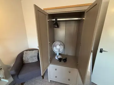 a room with a closet with a fan and a chair at Canal Side Retreat in Maldon