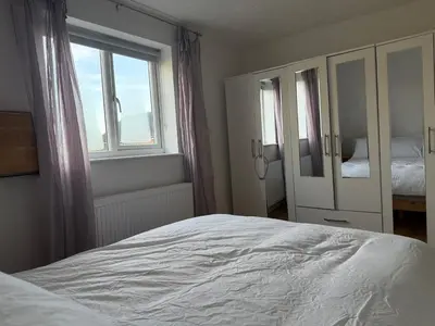 a bedroom with a white bed and a window at Entire House with Garden and Office in Milton