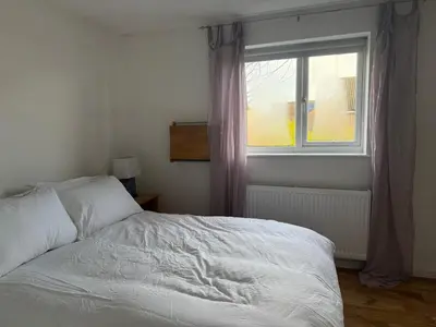 a bedroom with a white bed and a window at Entire House with Garden and Office in Milton