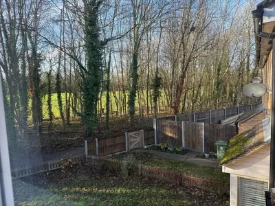 a garden with a fence and some trees at Entire House with Garden and Office in Milton