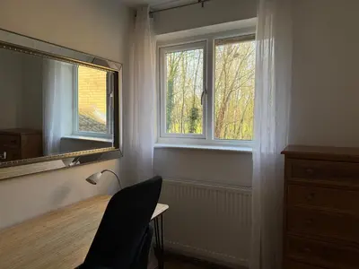 a room with a desk with a mirror and two windows at Entire House with Garden and Office in Milton