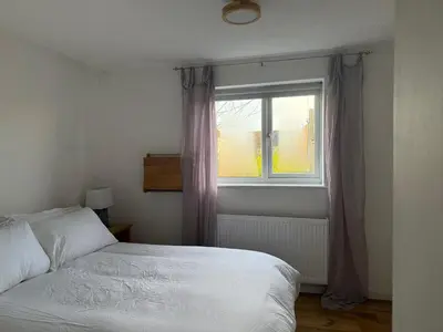 a bedroom with a bed and a window at Entire House with Garden and Office in Milton