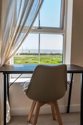 a desk with a chair in front of a window at Serene Sands in Felixstowe