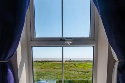 a window in a room with a view of a field at Serene Sands in Felixstowe