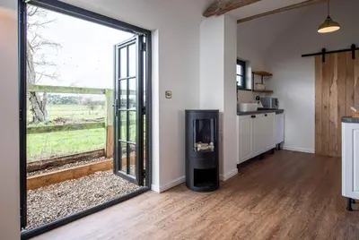 a room with a large glass door leading to a kitchen at The Acorn - Roudham Norwich in Norwich