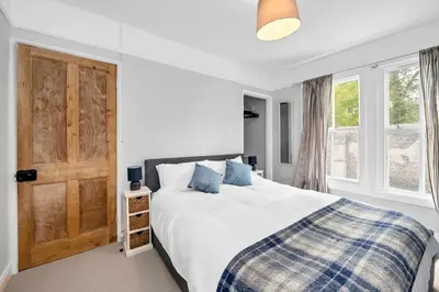 a bedroom with a bed and a wooden door at 10 Mustow St - Charming 3 bed home next to the Abbey Gardens in Bury St Edmunds in Bury Saint Edmunds
