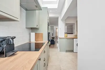 a kitchen with white cabinets and a counter top at 10 Mustow St - Charming 3 bed home next to the Abbey Gardens in Bury St Edmunds in Bury Saint Edmunds