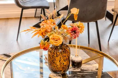 a vase with flowers sitting on a glass table at Lux 2 Bedroom Flt at Brentwood in Brentwood