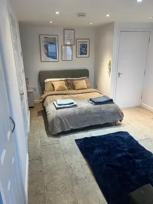 a bedroom with a bed and a blue rug at Riverlight Studio sleep 3 in Cambridge