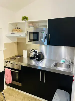 a small kitchen with a sink and a microwave at Riverlight Studio sleep 3 in Cambridge
