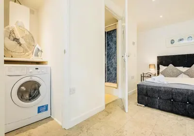 a bedroom with a bed and a washing machine at Riverlight Studio sleep 3 in Cambridge