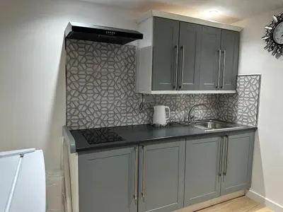 a kitchen with gray cabinets and a sink at A Cosy and Luxurious Studioflat in Navestock