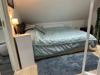 a small bedroom with a bed and a mirror at A Cosy and Luxurious Studioflat in Navestock