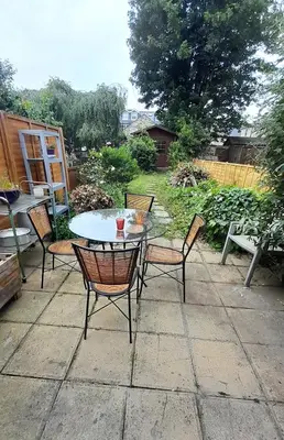 a patio with a table and chairs on a patio at Lovely artist's home ecently refurbished in CBG