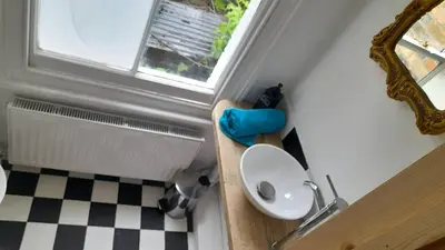 a bathroom with a toilet and a sink and a window at Lovely artist's home ecently refurbished in CBG