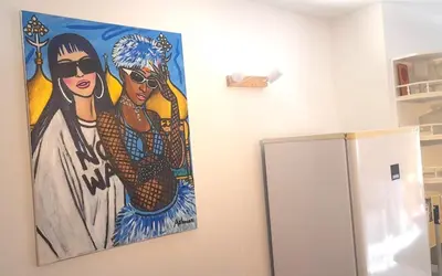 a painting of two women on a wall next to a refrigerator at Lovely artist's home ecently refurbished in CBG