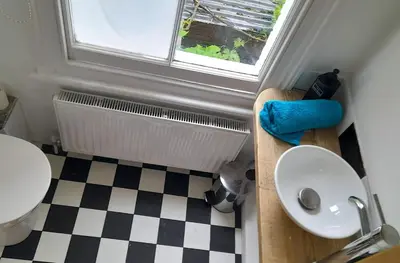 a bathroom with a sink and a toilet and a window at Lovely artist's home ecently refurbished in CBG