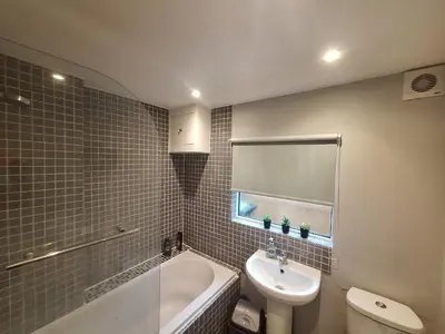 a bathroom with a sink and a toilet and a tub at Room in Stowmarket in Stowmarket